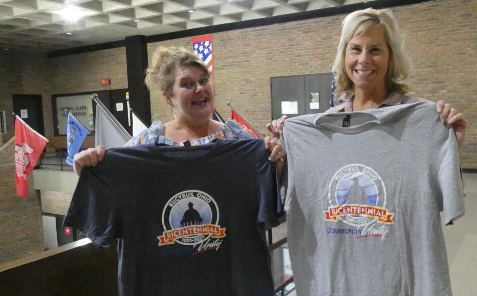 Rhonda Rowland, left, and Kelli Patterson of the Bucyrus Bicentennial Commission display commemorative T-shirts that are now on sale.