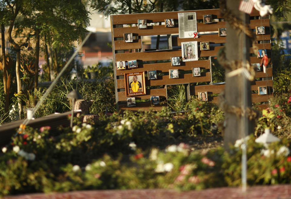 In this Friday, Sept. 21, 2018, photo, a photo of Las Vegas shooting victim Erick Silva, center, hangs on a wall at a memorial garden under construction in Las Vegas. The small garden is home to photos, crosses, ribbons and dozens of other items placed in memory of the 58 people who were killed on Oct. 1, 2017, in the deadliest mass shooting in modern U.S. history. For their families and those who survived the massacre at a country music festival, this garden created by volunteers in the days that followed is a place to mourn and heal. (AP Photo/John Locher)