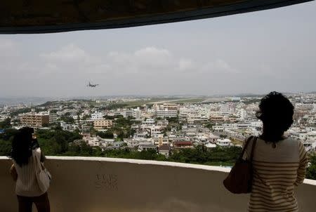 Visitors look out over U.S. Marine Corps Air Station Futenma in Ginowan on Okinawa May 3, 2010. REUTERS/Issei Kato/Files