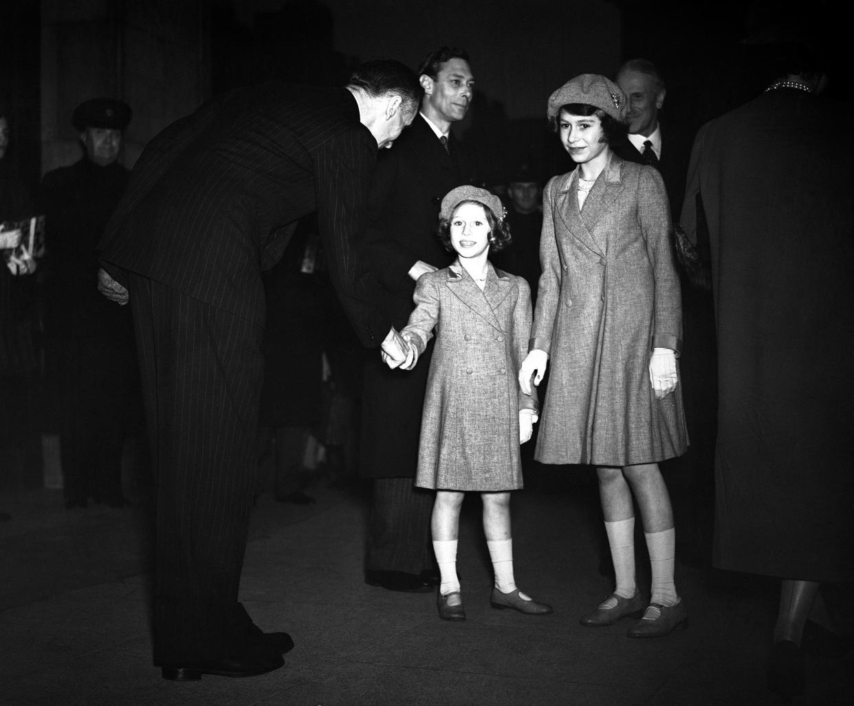 The Royal Family visited the B.B.C. at Broadcasting house in London on March 13, 1939. Princess Margaret Rose and Princess Elizabeth shaking hands with Frederick Ogilvie, Director General of the B.B.C. after the Royal family's tour. 