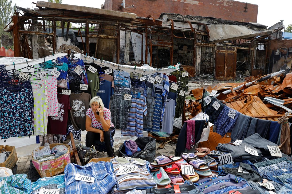 A street vendor waits for customers at a destroyed market in Donetsk (REUTERS)