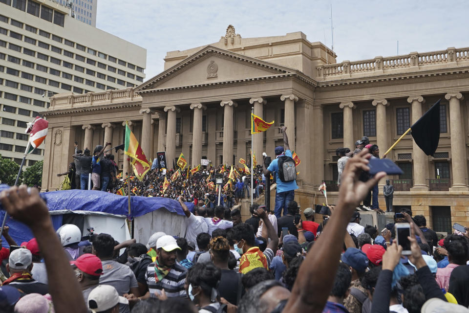 Protesters, many carrying Sri Lankan flags, gather outside the presidents office in Colombo, Sri Lanka, Saturday, July 9, 2022. Sri Lankan protesters stormed President Gotabaya Rajapaksa's residence and nearby office on Saturday as tens of thousands of people took to the streets of the capital Colombo in the biggest demonstration yet to vent their fury against a leader they hold responsible for the island nation's worst economic crisis. (AP Photo/Thilina Kaluthotage)