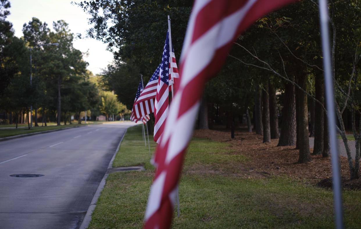 Image: Flags decorate Cutten Road, near a Fallen Warriors Memorial, in Prestonwood Forest. (Lizzie Chen / for NBC News)