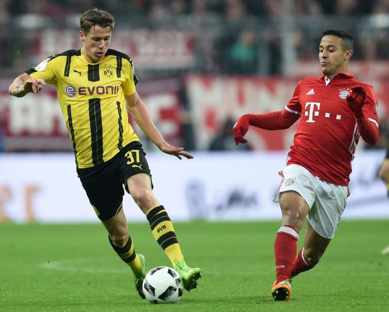 Dortmund's Erik Durm (left) and Bayern Munich's Thiago Alcantara in action during the German Cup semi-final match in Munich, on April 26, 2017