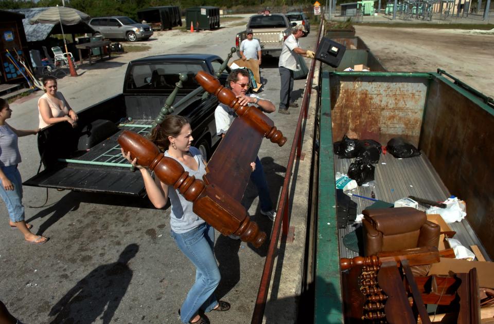 Falynn Summerlin, bottom center, is assisted by Justin Diggs while dropping off an old headboard at Indian River County's Oslo Convenience Center, located on Old Dixie Highway in Vero Beach, on Tuesday Jan. 22, 2008.