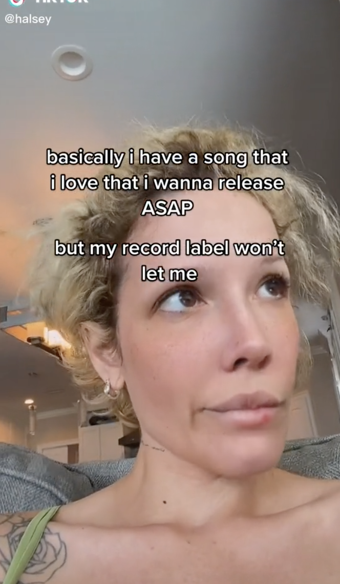 Closeup of Halsey on TikTok with text that says, "basically i have a song that i love that i wanna release ASAP but my record label won't let me"