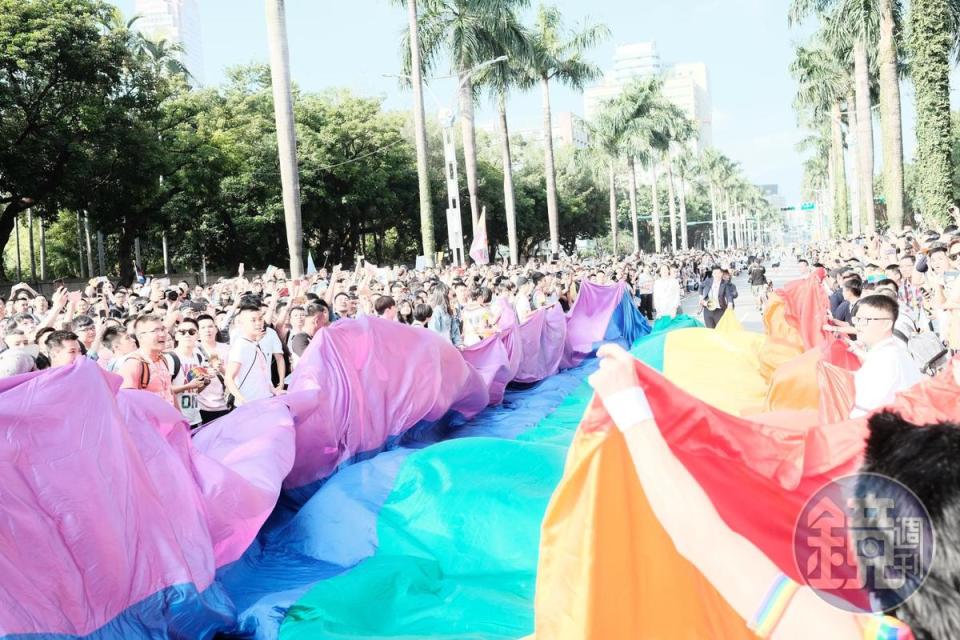 民眾鋪上彩虹旗，引起群眾圍觀、爭相拍照留念。