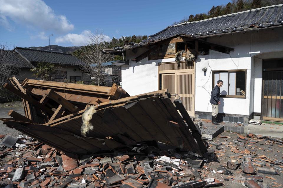 Sushi maker Akio Hanzawa walks in front of his damaged restaurant in Shiroishi, Miyagi (AFP via Getty Images)