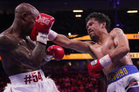 Manny Pacquiao, right, of the Philippines, hits Yordenis Ugas, of Cuba, in a welterweight championship boxing match Saturday, Aug. 21, 2021, in Las Vegas. (AP Photo/John Locher)