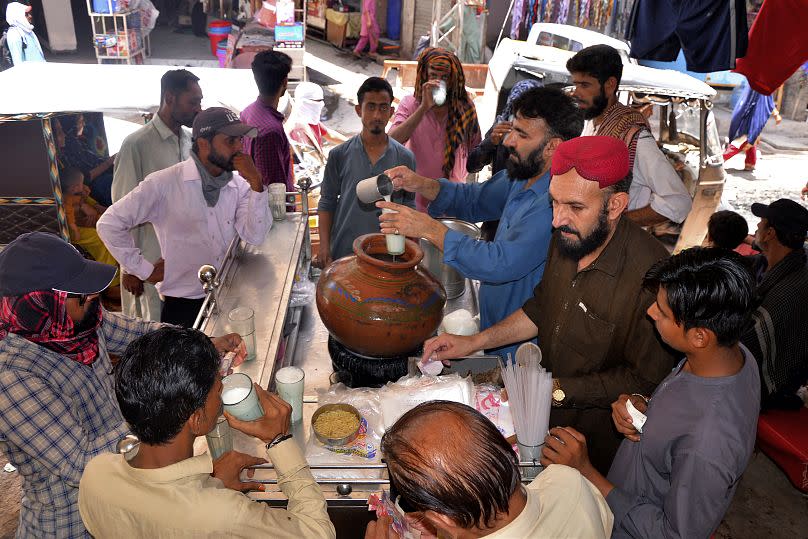 An einem Stand in Hyderabad, Pakistan, trinken Menschen gesüßtes Wasser.