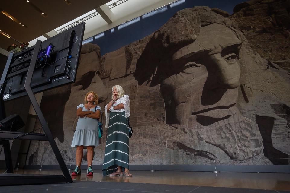 Ocean Ridge residents Barbara Tuck, left and Gayle 'Mya' Breman watch a video presentation in front of a set backing used in "North by Northwest" (1959) at the new exhibition "Art of the Hollywood Backdrop" at the Boca Raton Museum of Art in Boca Raton.