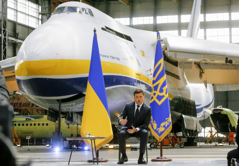 El presidente ucraniano Volodymyr Zelenskyy habla durante una conferencia de prensa teniendo de fondo el avión más grande del mundo, el An-225 Mriya de Antonov, en la fábrica de aeronaves Antonov en Kiev, Ucrania, el jueves 20 de mayo de 2021. (AP Foto/Efrem Lukatsky)