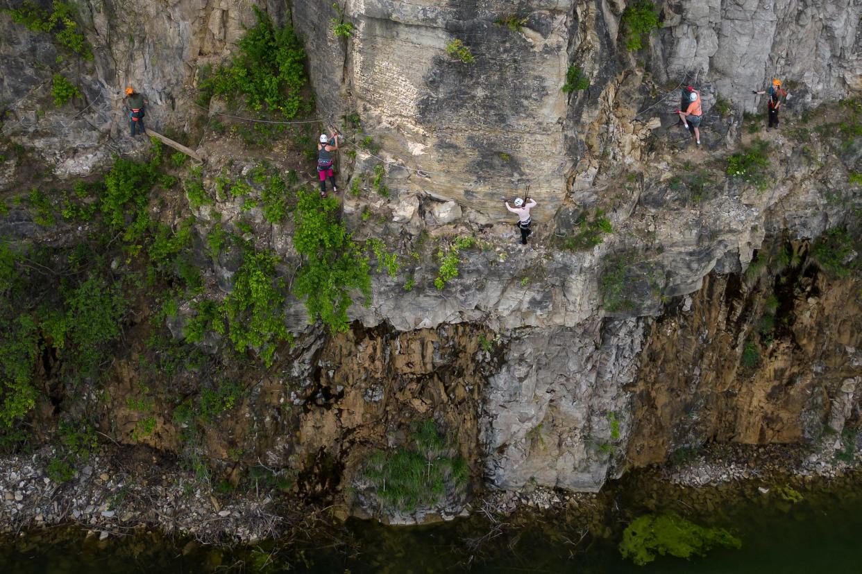 Climbers use cables and metal rungs to traverse the via ferrata rock wall at Quarry Trails Metro Park in Columbus on May 11. The 1,040-foot guided climb, believed to be the first urban via ferrata in the country, reaches heights of over 100 feet.
