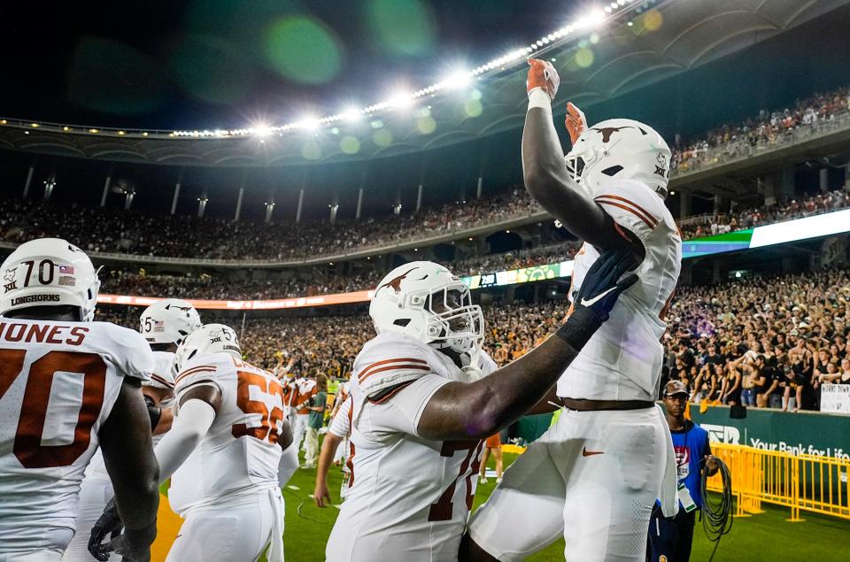 Texas left tackle Kelvin Banks Jr., left, and running back CJ Baxter celebrate a touchdown against Baylor in September. Both players will return for Texas in 2024.