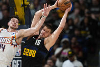 Denver Nuggets center Nikola Jokic grabs a rebound next to Phoenix Suns forward Drew Eubanks during the second half of an NBA basketball game Wednesday, March 27, 2024, in Denver. (AP Photo/David Zalubowski)