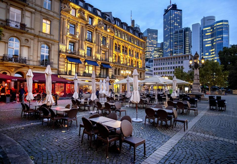 Sillas y mesas yacen sin comensales el miércoles 28 de octubre de 2020 en la Plaza de la Ópera, en Fráncfort, Alemania. (AP Foto/Michael Probst)