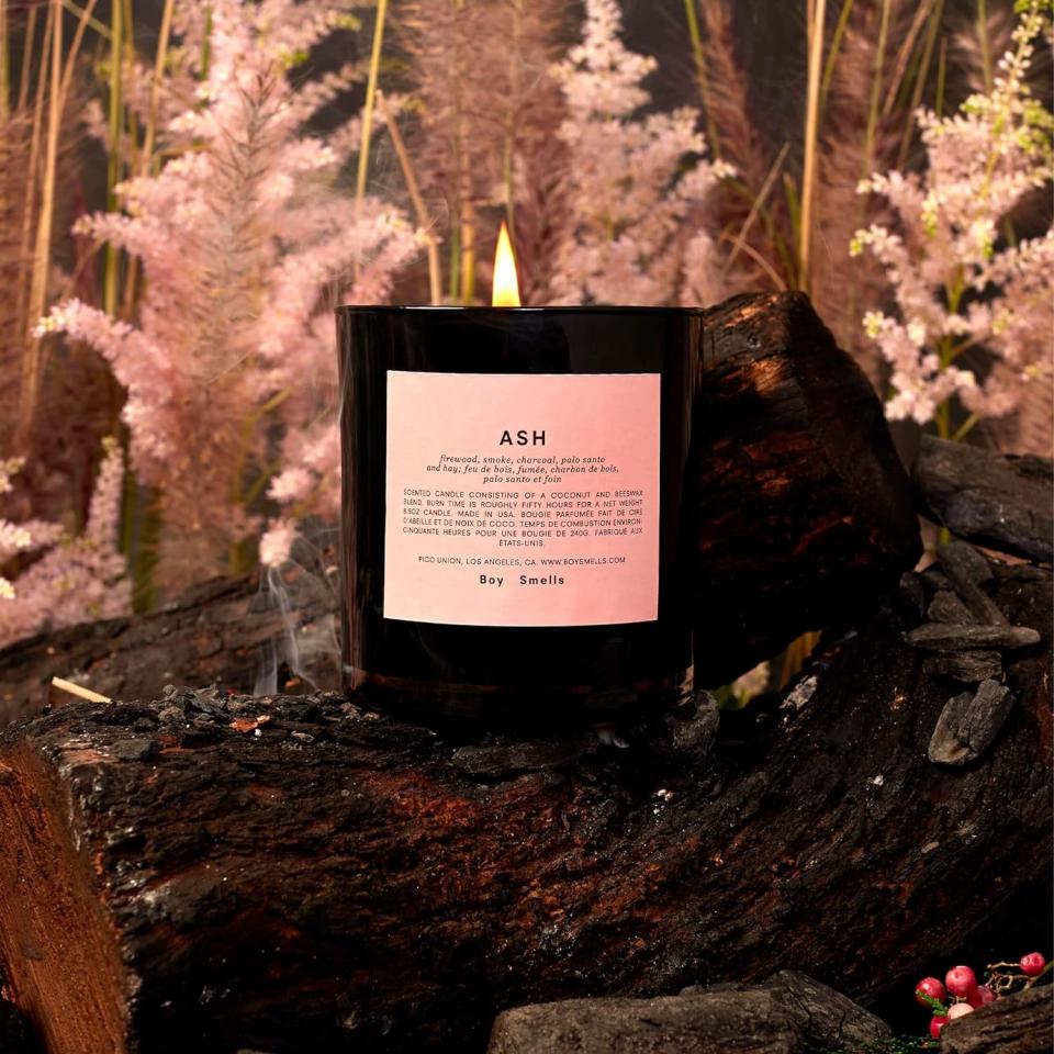 black and pink candle lit on top of log