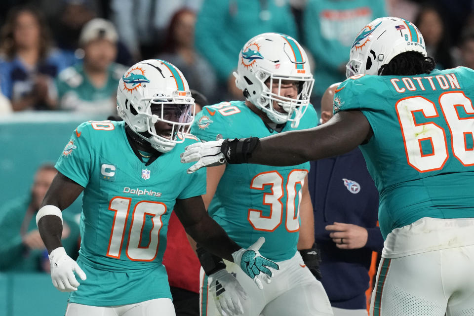 Miami Dolphins wide receiver Tyreek Hill (10) is congratulated by guard Lester Cotton (66) after making a catch during the second half of an NFL football game against the Tennessee Titans, Monday, Dec. 11, 2023, in Miami. (AP Photo/Rebecca Blackwell)