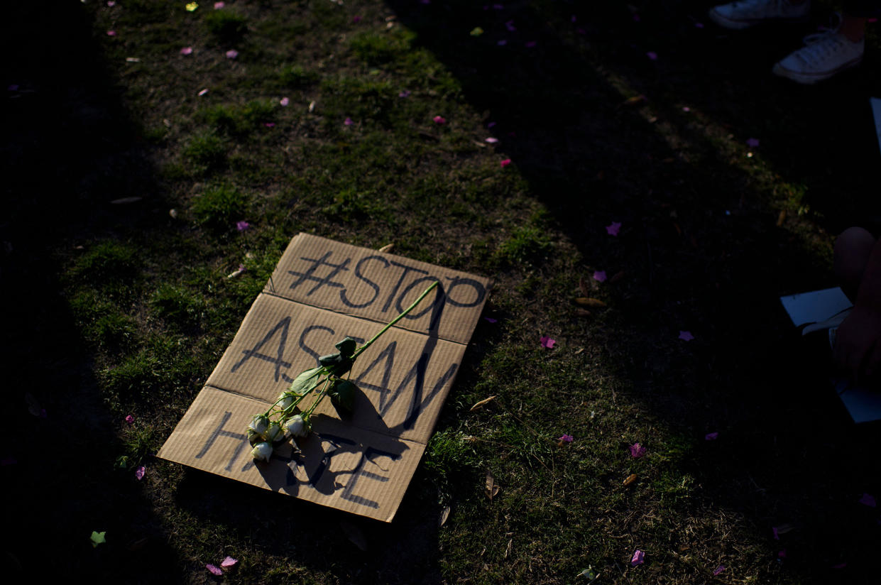 A sign is laid on the grass during a Stop Asian Hate rally in Houston on March 20, 2021.