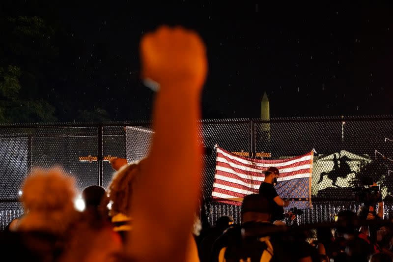 A man raises his fist in front of the White House during a protest against the death in police custody of George Floyd