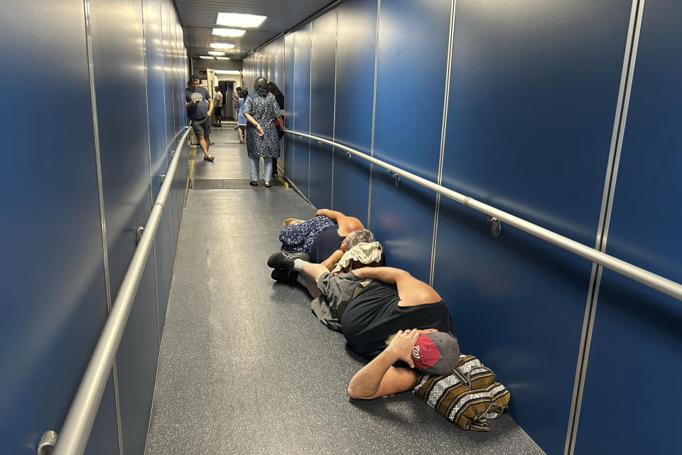 Viajeros en el Aeropuerto Internacional de Los Ángeles, duermen en un pasillo por una demora en un vuelo de United Airlines debido a una caída generalizada de internet global, el 19 de julio de 2024, en Los Ángeles. (AP Foto/Stefanie Dazio)