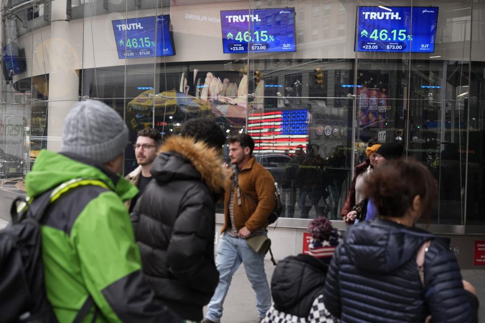 Pedestrians walk past the Nasdaq building Tuesday, March 26, 2024, in New York. Trump Media, which runs the social media platform Truth Social, now takes Digital World's place on the Nasdaq stock exchange. (AP Photo/Frank Franklin II)