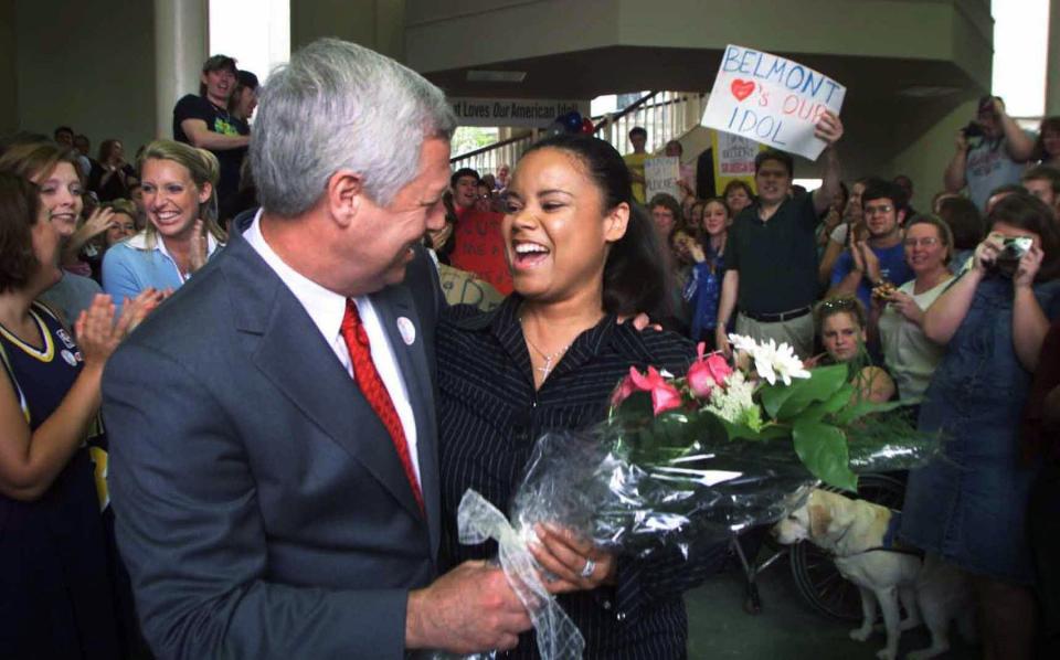 American Idol 2 finalist Kimberley Locke, right, is being greeted by Belmont University President Dr. Robert C. Fisher as members of the student body applaud her at the school May 9, 2003. With American idol TV crew and Fox network entourage in tow, Locke, visited her college as well as her old high school, Gallatin High, and some media outlets in between.