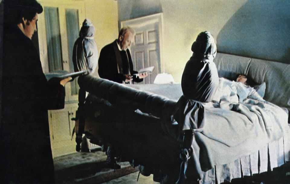 Fathers Karras and Merrin standing by Regan in her floating bed in "The Exorcist"