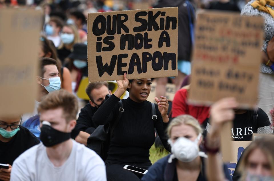 <i>A protester at an anti-racism demonstration in London on June 3 holds a sign that reads: "Our skin is not a weapon." </i>