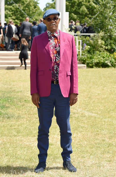 Samuel L. Jackson just walked in his first fashion show (for charity) and now he’s sitting front row. Wearing a fuchsia blazer, navy blue trousers, a printed button down, and round frame sunglasses, the actor topped his ensemble off with a hat, just one of the around 300 he has in his collection (most are bucket hats). The surprising fashionista recently said of his style, “My choice of clothes depends on where I’m going. If it’s a premiere I try to choose something appropriate to the theme of film. If it’s a serious film, I’ll wear a suit. If not, I’ll present myself as Samuel L Jackson who likes to have fun.”