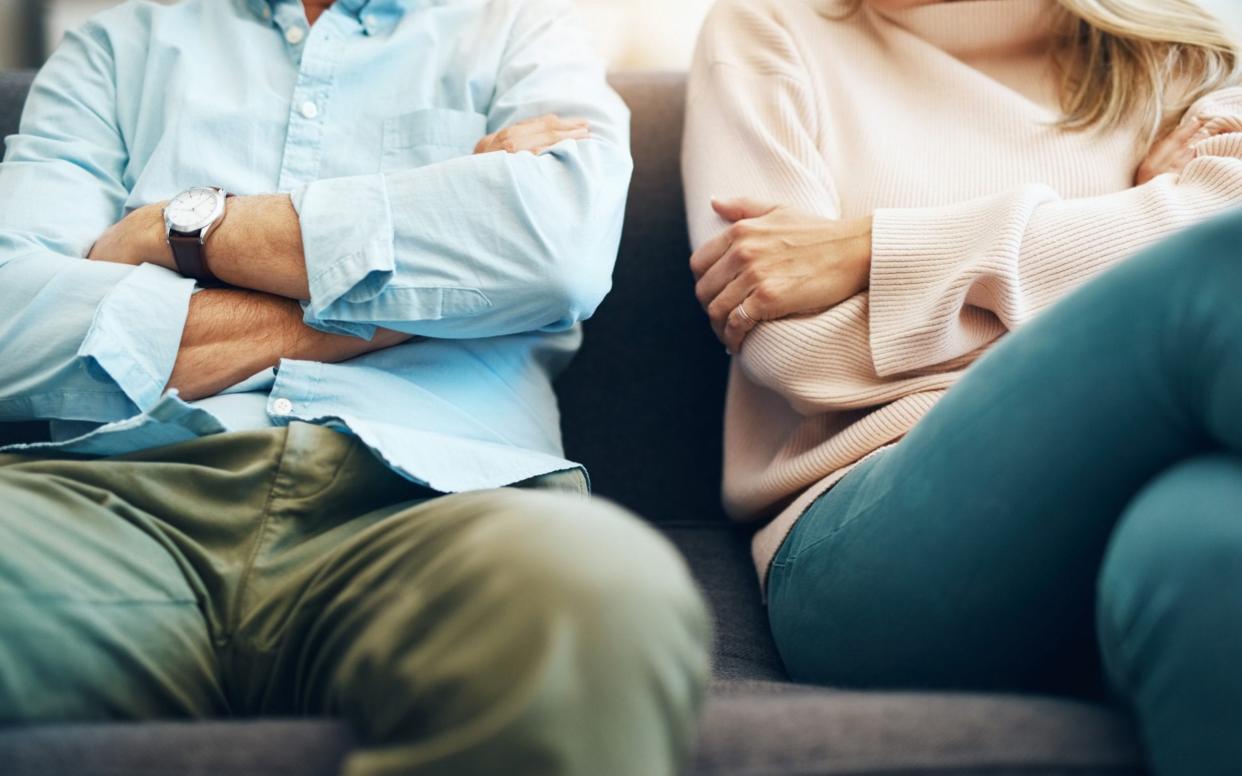 Couple look unhappy sitting next to each other - PeopleImages 