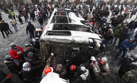 Demonstrators pull a burnt vehicle during a rally held by pro-European integration protesters in Kiev January 21, 2014. REUTERS/Vasily Fedosenko