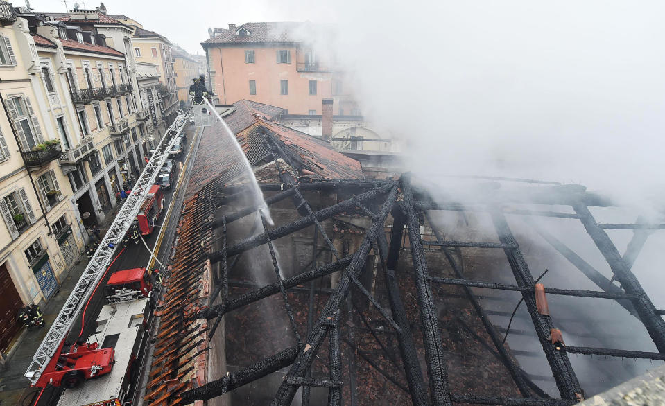 Firefighters put out a fire on the rooftop of the Cavallerizza Reale, in Turin, northern Italy, Monday, Oct. 21, 2019. A big fire broke out on Monday at Turin's Cavallerizza Reale, a historic building in the centre of the northern city which has UNESCO World Heritage status thanks to its special architectural features, no injuries were reported. (Alessandro Di Marco/ANSA via AP)