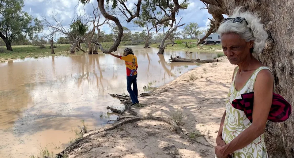 Polly Cutmore (right) standing by a waterhole on the Pilliga