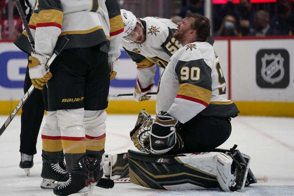 Vegas Golden Knights defenseman Dylan Coghlan (52) checks on Golden Knights goaltender Robin Lehner (90) after Lehner took a puck to the helmet during the second period of an NHL hockey game against the Washington Capitals, Monday, Jan. 24, 2022, in Washington. (AP Photo/Evan Vucci)