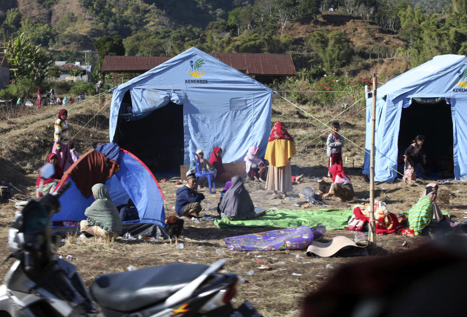 People affected by an earthquake sit outside their makeshift tents in Sembalun, on Lombok Island, Indonesia, Monday, Aug. 6, 2018. The powerful earthquake struck the Indonesian tourist island of Lombok, killing a number of people and shaking neighboring Bali, as authorities on Monday said thousands of houses were damaged and the death toll could climb. (AP Photo/Adrial Pranandi)