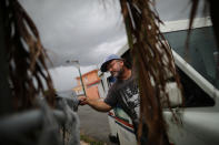 <p>Alfredo Martinez, a mail man for the U.S. Postal Service delivers the mail at an area damaged by Hurricane Maria in San Juan, Puerto Rico, Oct. 6, 2017. (Photo: Carlos Barria/Reuters) </p>