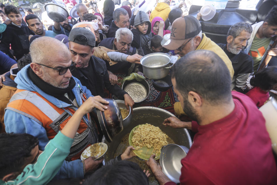 Palestinians line up for food in Rafah, Gaza Strip, Thursday, Nov. 30, 2023, during a temporary ceasefire between Israel and Hamas. (AP Photo/Hatem Ali)