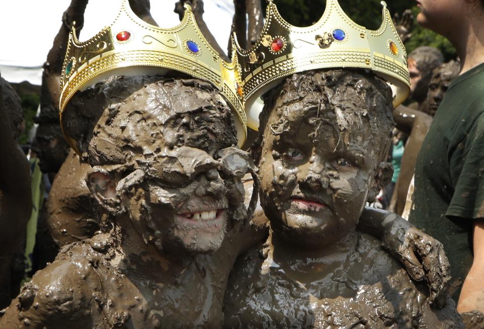 Mud Day Queen Riley Tulgetske, left, embraces Mud Day King Phoenix Crowder during Mud Day at the Nankin Mills Park, Tuesday, July 9, 2019, in Westland, Mich. The annual day is for kids 12 years old and younger. While parents might be welcome, this isn't an event meant for teens or adults. It's all about the kids having some good, unclean fun during their summer break and is sponsored by the Wayne County Parks. (AP Photo/Carlos Osorio)