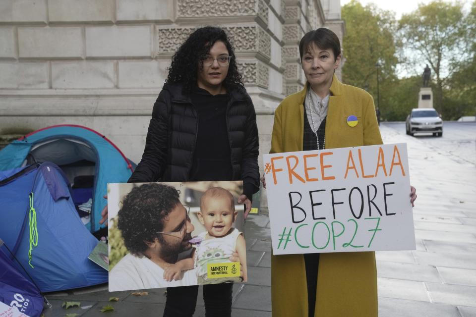 Sanaa Seif, sister of Egypt's leading pro-democracy activist Alaa Abdel-Fattah, left, poses with Caroline Lucas, Green Party MP outside the Foreign Office in London, Tuesday, Nov. 1, 2022. The family of Egypt's most prominent imprisoned activist says he began a "full hunger strike" on Tuesday and plans to stop drinking water as of Sunday, the first day of the global climate summit, or COP27, that Egypt is hosting this month. (AP Photo/Kin Cheung)