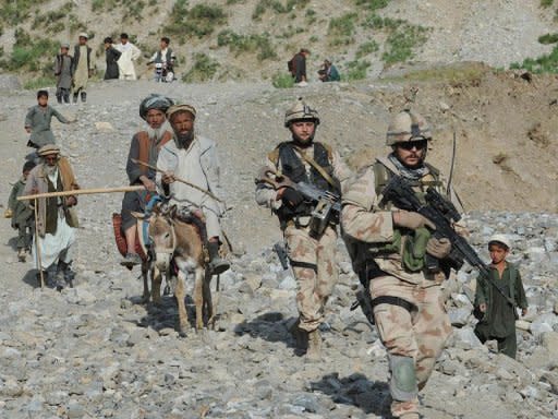 NATO-led International Security Assistance Force (ISAF) soldiers walk with Afghan villagers during a search for victims following an earthquake in a village in Baghlan province on June 12. Iran on Thursday warned a key international conference that a long-term US military presence in Afghanistan would fan regional insecurity and could plunge the war-torn country back into further chaos