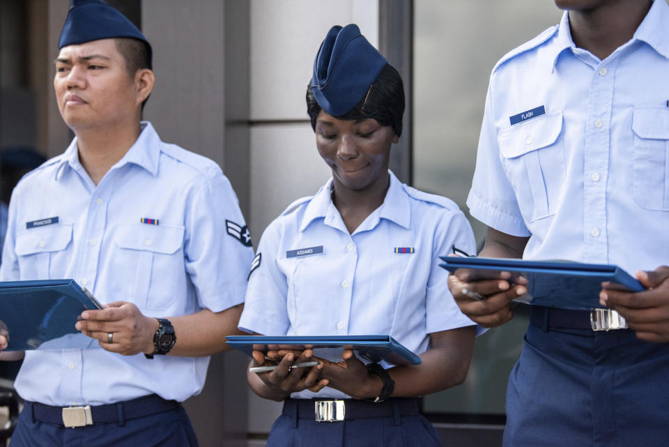 Airman 1st Class Joshua Fancisco, from the Philippines, left, Airman 1st Class D'elbrah Assamoi, from Cote D'Ivoire, center, and Airman 1st Class Jordan Flash, from Jamaica, looks at their U.S. Certificate of Citizenship after signing it following the Basic Military Training Coin Ceremony on April 26, 2023, at Joint Base San Antonio-Lackland, Texas. The U.S. military has struggled to overcome recruiting shortfalls and as a way to address that problem, it's stepping up efforts to sign up immigrants, offering a fast track to American citizenship to those who join the armed services. (Christa D'Andrea/U.S. Air Force via AP)