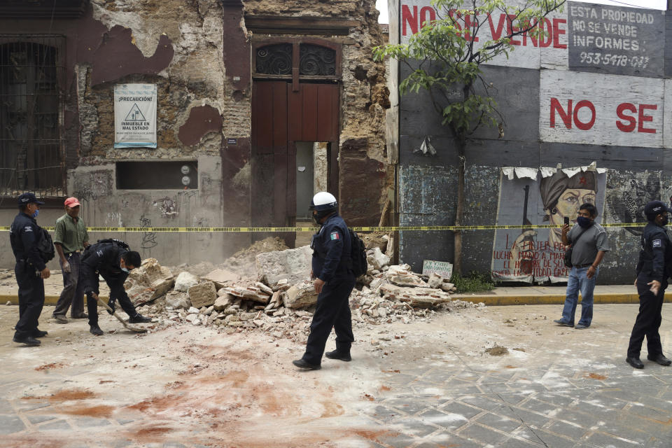 A policeman removes rubble from a building damaged by an earthquake in Oaxaca, Mexico, Tuesday, June 23, 2020. The earthquake was centered near the resort of Huatulco, in the southern state of Oaxaca. (AP Photo/Luis Alberto Cruz Hernandez)