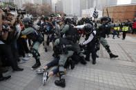 FILE - Police detain protesters during a rally to show support for Uighurs and their fight for human rights in Hong Kong, Sunday, Dec. 22, 2019. The recent wave of protests against China's anti-virus restrictions was a ray of hope for some supporters of Hong Kong's own pro-democracy movement after local authorities stifled it using a national security law enacted in 2020, but not everyone agrees. (AP Photo/Lee Jin-man, File)