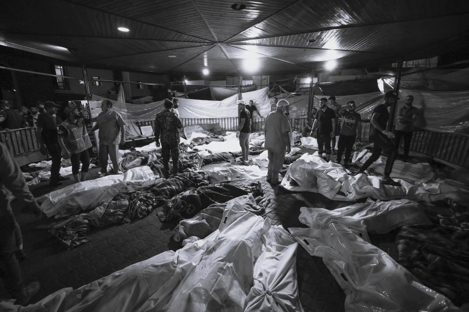 <strong>加薩中部的阿里阿拉伯醫院（Al-Ahli al-Arabi Hospital）遇襲，醫院外堆滿死者屍體。（圖／美聯社）</strong>