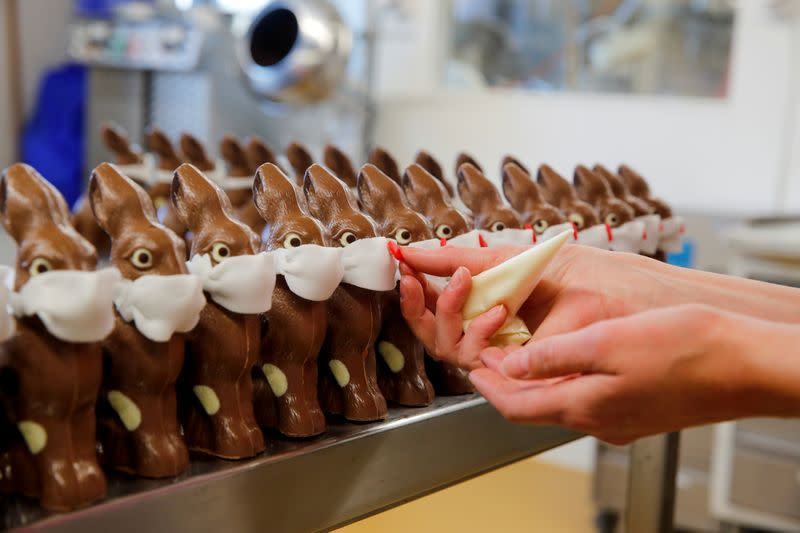 FILE PHOTO: An employee prepares chocolate Easter bunnies wearing protective masks at Baeckerei Bohnenblust bakery in Bern