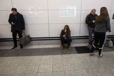 People use their phones at LaGuardia airport on the day before Thanksgiving, in New York November 26, 2014. REUTERS/Carlo Allegri