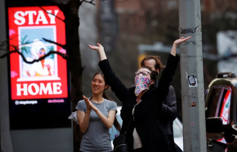 People stand and cheer healthcare workers outside Mount Sinai West Hospital at 7pm during outbreak of coronavirus disease (COVID-19) in New York