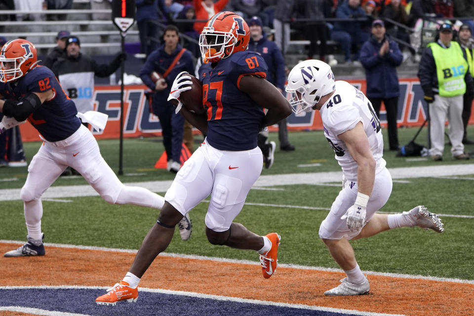 Illinois tight end Daniel Barker scores past Northwestern linebacker Peter McIntyre during the first half of an NCAA college football game Saturday, Nov. 27, 2021, in Champaign, Ill. (AP Photo/Charles Rex Arbogast)