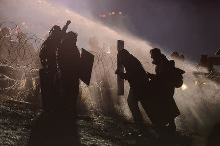 Police use a water cannon on protesters during a protest against plans to pass the Dakota Access pipeline near the Standing Rock Indian Reservation, near Cannon Ball, North Dakota. REUTERS/Stephanie Keith